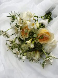 cream and white real flower bouwuet hand ties on a white chiffon cloth