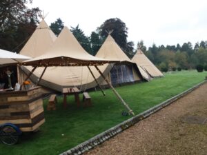 teepee set up on grass in a wooded area