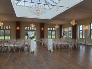 Interior of a ballroom with roof window, a wooden floor with chairs set up for a ceremony