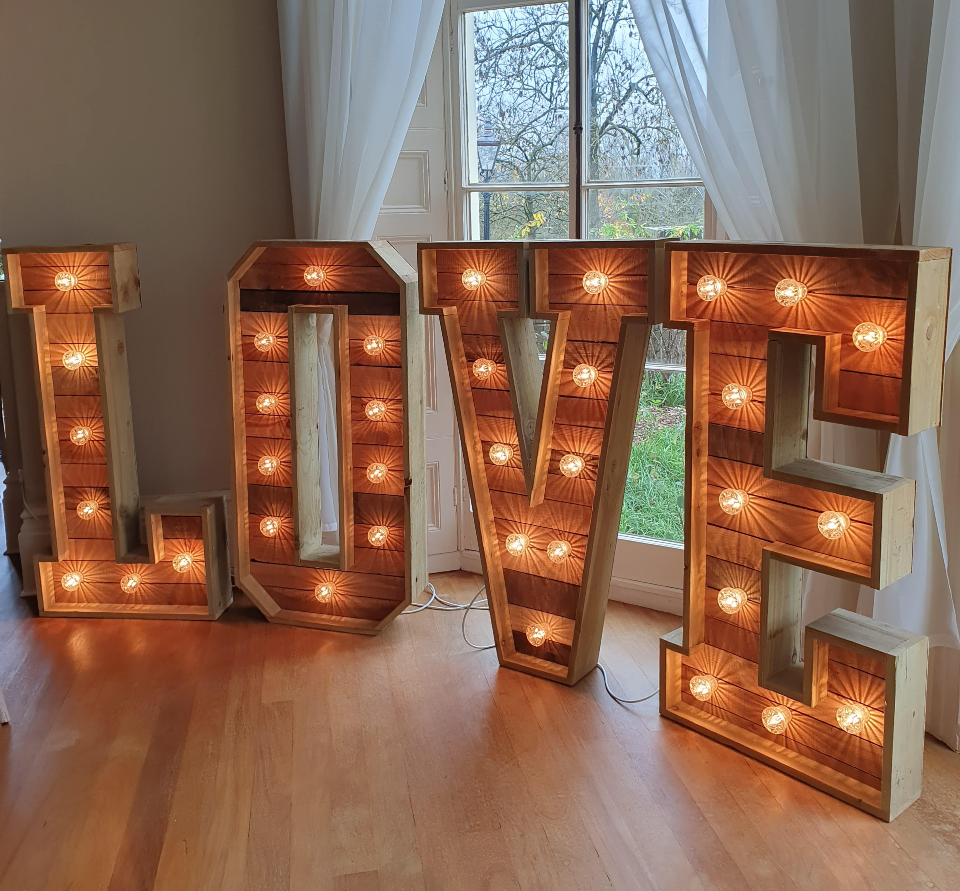 rustic wooden love letters in front of french doors with white drapes