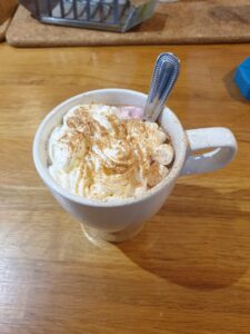 mug of hot cocoa with whipped cream & gold sprinkles